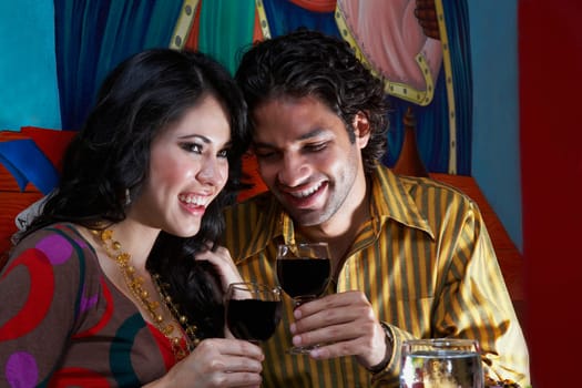 Close-up of a young couple holding glasses of red wine