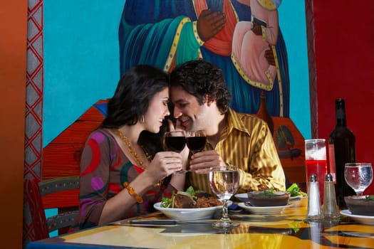 Side profile of a young couple toasting wine in a restaurant