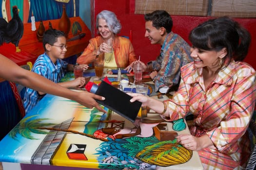Mature woman paying bill by a credit card in a restaurant