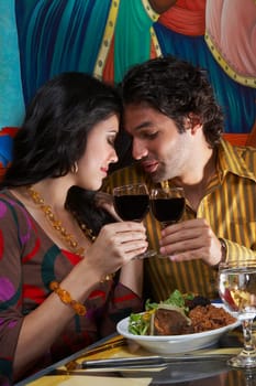 Side profile of a young couple toasting wine in a restaurant