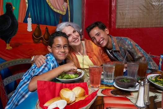 Two boys sitting with their grandmother in a restaurant