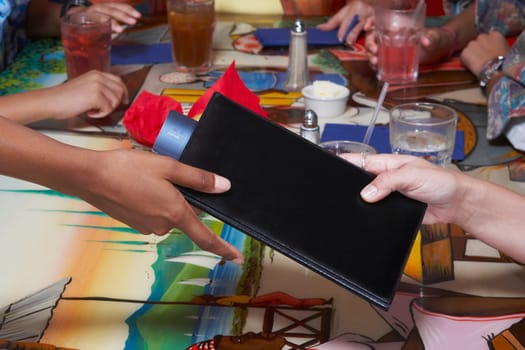 Close-up of a person's hand paying bill by credit card in a restaurant