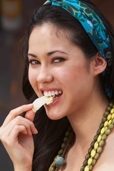 Close-up of a young woman eating potato chips