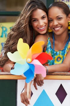 Portrait of two young women smiling and holding a pinwheel