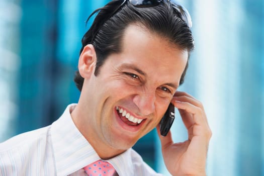 Close-up of a businessman talking on a mobile phone and smiling