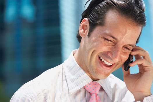 Close-up of a businessman talking on a mobile phone and smiling