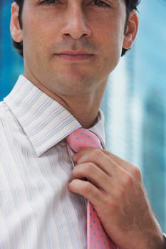 Portrait of a businessman adjusting his tie