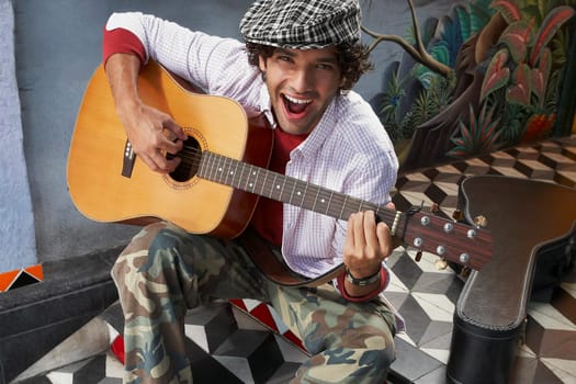 High angle view of a young man playing a guitar