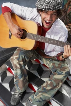 High angle view of a young man playing a guitar