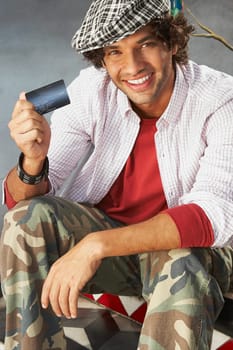 Portrait of a young man holding a credit card and smiling