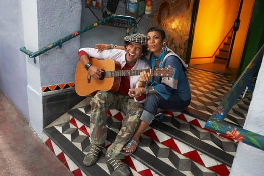 High angle view of a young man singing with a young woman and playing a guitar