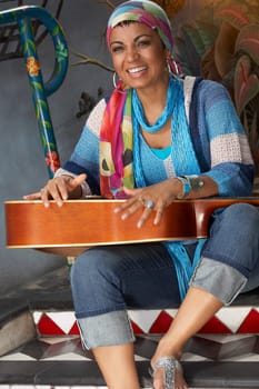 Young woman smiling and holding a guitar