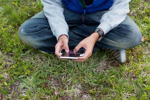 Low section view of a teenage boy using a mobile phone