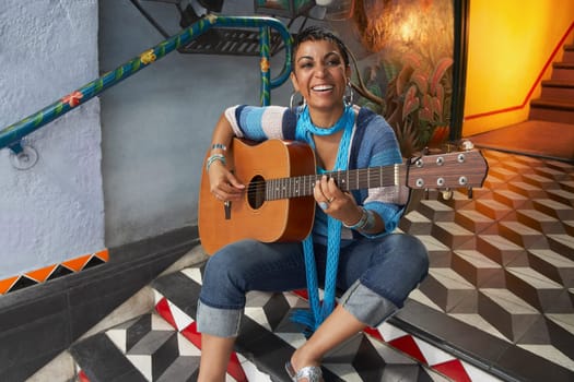 Portrait of a young woman playing a guitar