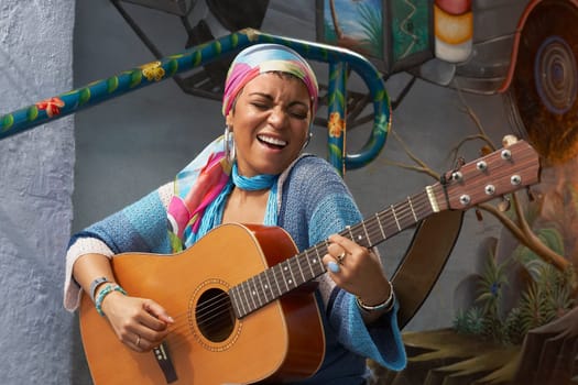 Young woman playing a guitar and singing
