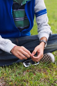 Low section view of a teenage boy sitting in a park
