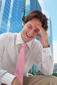 Low angle view of a businessman smiling with his head in his hands