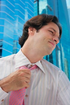 Close-up of a businessman pulling his tie