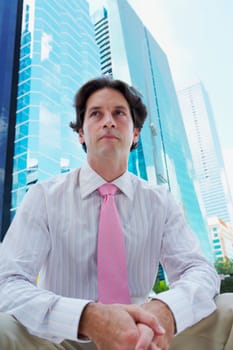 Low angle view of a businessman sitting in front of a building