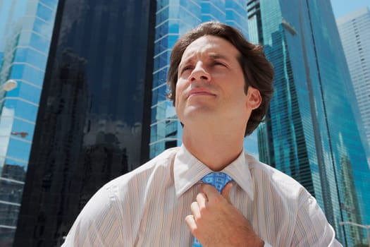 Close-up of a businessman adjusting his tie