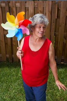 High angle view of a senior woman holding a pinwheel