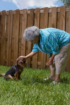 Side profile of a senior woman loving a dog
