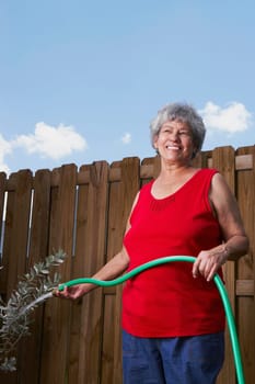 Senior woman watering a plant