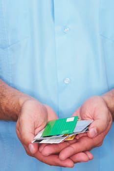Mid section view of a man holding various types of credit cards