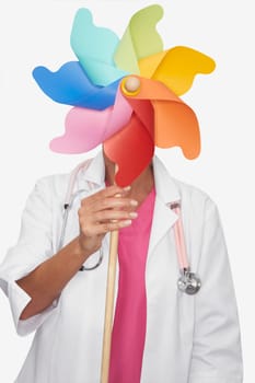 Close-up of a female doctor holding a pinwheel in front of her face