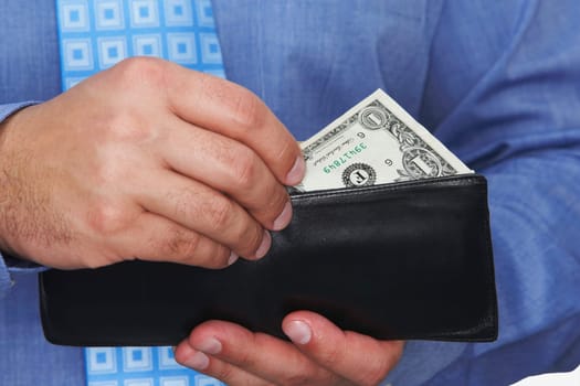Mid section view of a businessman taking one dollar bill out of his wallet
