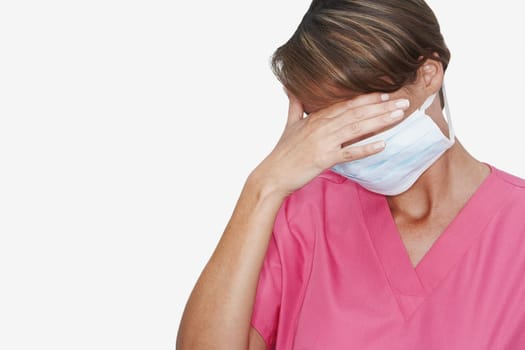 Female doctor wearing a surgical mask with hand over eyes