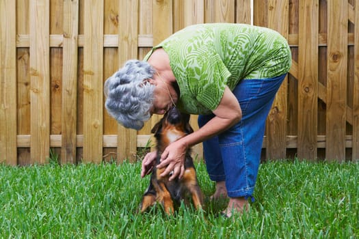 Side profile of a senior woman kissing a dog
