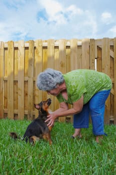 Side profile of a senior woman kissing a dog