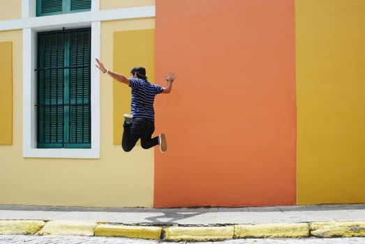 Rear view of a man jumping at the roadside