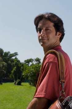 Portrait of a mid adult man carrying a golf bag