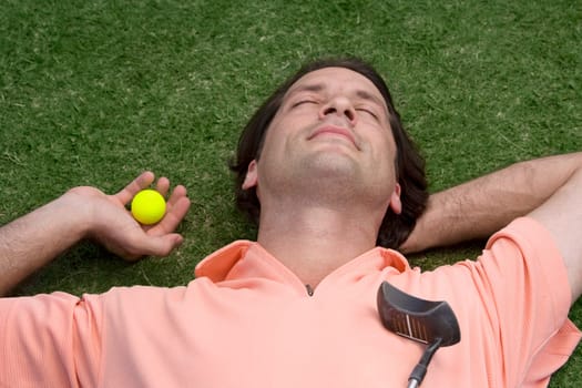 Close-up of a mid adult man lying on a golf course