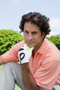 Portrait of a mid adult man holding a golf ball