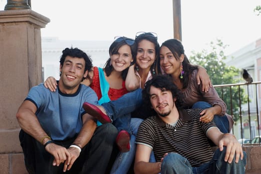 Portrait of three young women smiling with two young men