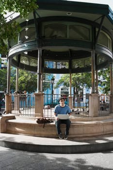 Portrait of a young man sitting and using a laptop