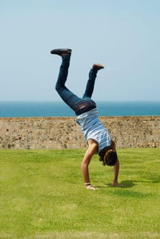 Rear view of a man doing a handstand in a park