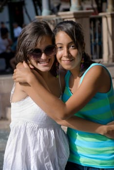 Portrait of two young women smiling and embracing each other