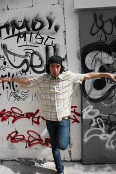 Portrait of a young man posing in front of a wall