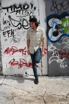 Young man leaning against a wall