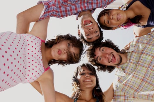 Low angle view of three young women and two young men in a huddle