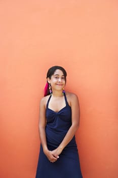 Portrait of a young woman leaning against a wall