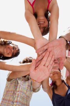Low angle view of three young women and two young men in a huddle