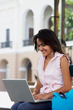 Close-up of a young woman using a laptop and smiling, Old San Juan, San Juan, Puerto Rico