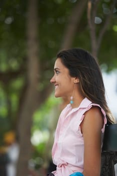 Side profile of a young woman smiling and looking away