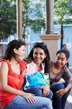 Three young women sitting together and smiling, Old San Juan, San Juan, Puerto Rico