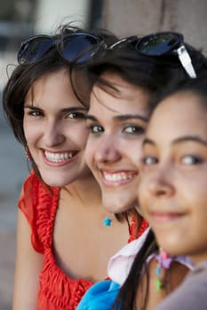 Portrait of three young women sitting and smiling